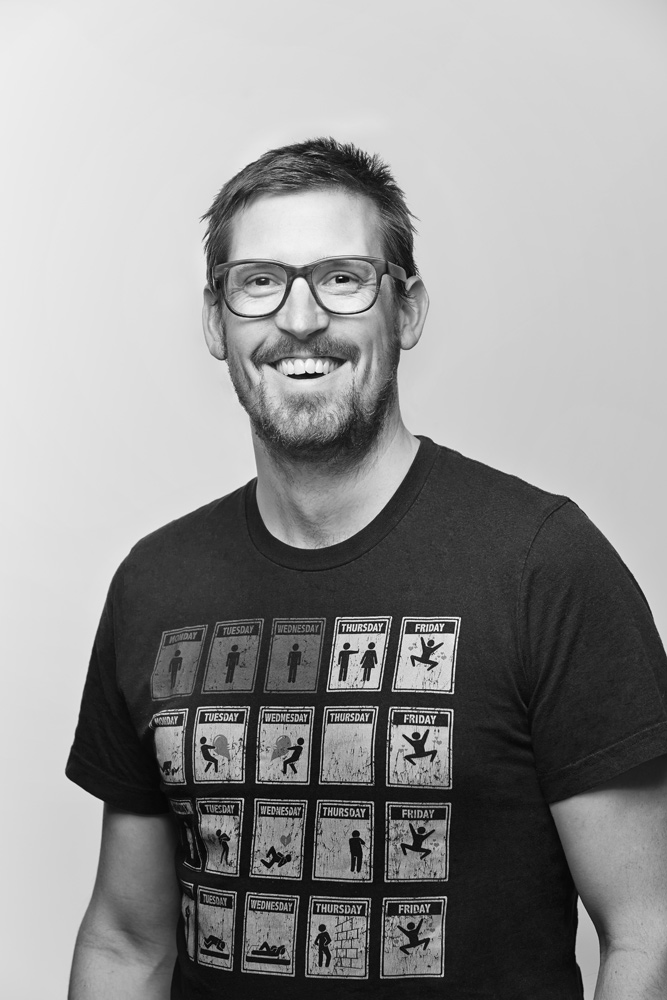 Smiling man wearing glasses and graphic T-shirt